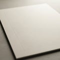 A close-up of a blank, lined notepad on a smooth, light gray surface. The notepad is oriented at a Royalty Free Stock Photo