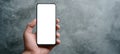 The close-up of a blank smartphone held in a hand against a textured background. AI generated image Royalty Free Stock Photo