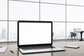 Close up of blank white laptop computer screen on wooden office desktop with supplies on panoramic window and city view background Royalty Free Stock Photo