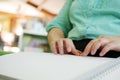 Close-up of blind person woman hands reading Braille book studying in creative library. Braille is a system of raised dots that