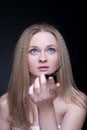 Close up of blond girl with feather on black Royalty Free Stock Photo