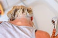 Blond woman shampooing her hair in a basin