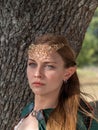 Close-up of blonde girl with blue eyes and elf ears wearing a green cape Royalty Free Stock Photo