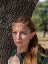 Close-up of blonde girl with blue eyes and elf ears wearing a green cape Royalty Free Stock Photo