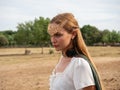 Close-up of blonde girl with blue eyes and elf ears wearing a green cape Royalty Free Stock Photo