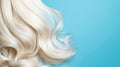 Close up of blonde woman\'s hair on blue background. Glossy wavy white hair