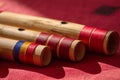 India, Close up of blowing hole of hindu bamboo flute called Bansuri on a red table.