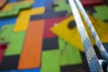 Close-up of a blue climbing rope hanging in front of a playful gym climbing wall.