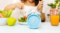 Close up of Blue clock  and Intermittent fasting program for diet plan which young woman Eating healthy breakfast bowl-Clean Royalty Free Stock Photo