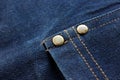 Close-up Blue Denim or jeans and metal buttons surface and texture background. Royalty Free Stock Photo