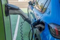 Close-up of a blue electric car charging the battery in an electric charger