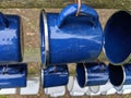 A close up of blue enamel mugs hanging up