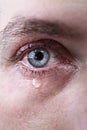 Close up of blue eye of man crying in tears sad and full of pain in depression Royalty Free Stock Photo