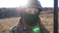 Close up blue eyes of female ukrainian army soldier looking into camera. Sight of young military woman in helmet and