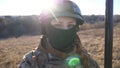 Close up blue eyes of female ukrainian army soldier looking into camera. Sight of young military woman in helmet and