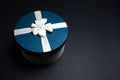 Close-up of blue gift box with white ribbon bow on black background with copy space. Royalty Free Stock Photo