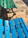 Close-up of blue and green painted wooden benches in a park area