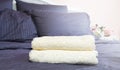 Close up of Blue inn linens and bath towel lying on bed. Hotel service and clean bedroom background. House room and home textile. Royalty Free Stock Photo