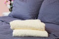 Close up of Blue inn linens and bath towel lying on bed. Hotel service and clean bedroom background. House room and home textile. Royalty Free Stock Photo