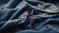 close up of blue jeans A denim fabric with rips and patches. The fabric is dyed with dark blue watercolor, creating a fade