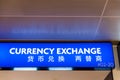 Close up of blue light currency exchange sign at international airport.