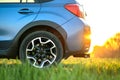 Close up of blue off road car on green grass. Traveling by auto, adventure in wildlife, expedition or extreme travel on a SUV Royalty Free Stock Photo