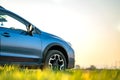 Close up of blue off road car on green grass. Traveling by auto, adventure in wildlife, expedition or extreme travel on a SUV Royalty Free Stock Photo