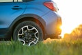 Close up of blue off road car on green grass. Traveling by auto, adventure in wildlife, expedition or extreme travel on a SUV Royalty Free Stock Photo