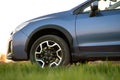 Close up of blue off road car on green grass. Traveling by auto, adventure in wildlife, expedition or extreme travel on a SUV Royalty Free Stock Photo