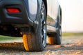 Close up of blue off road car wheel on gravel road. Traveling by auto, adventure in wildlife, expedition or extreme travel on a Royalty Free Stock Photo