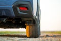 Close up of blue off road car wheel on gravel road. Traveling by auto, adventure in wildlife, expedition or extreme travel on a Royalty Free Stock Photo