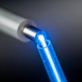 A close-up of a blue optical fiber cable emitting a bright light from its tip Royalty Free Stock Photo