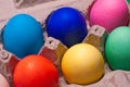 Close-up of blue, pink, red, yellow and green dyed eggs in cardboard egg carton Royalty Free Stock Photo