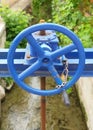 Close-up of blue, rusty gate valve with metal crank. Blue manual valve closure of water tank. Rusty vintage object. Gardening Royalty Free Stock Photo