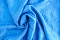 Close-up of blue satin fabric with a crinkled texture