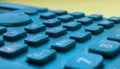 Close-up of a blue scientific calculator`s buttons, over a blurred yellow background Royalty Free Stock Photo