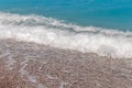 Close up blue sea water waves with bubbles on sand beach Royalty Free Stock Photo