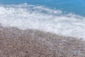 Close up blue sea water waves on sand beach with bubbles Royalty Free Stock Photo