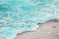 Close up blue sea water waves with white bubbles on sand beach Royalty Free Stock Photo