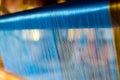 Close Up of Blue Silk on the Weaving machine and Thai traditional Silk. Weaving loom for homemade Silk textile. Royalty Free Stock Photo