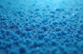 Close-up of blue sponge texture reveals numerous small pores. The material displays a uniform pattern and soft surface. It has an Royalty Free Stock Photo