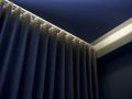 Close-up of blue wall curtain on curtain rail decorated with hidden light under the ceiling. Royalty Free Stock Photo