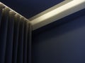 Close-up of blue wall curtain on curtain rail decorated with hidden light under the ceiling. Royalty Free Stock Photo