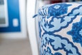 Close up of a blue and white fabric laundry basket a decorative storage box with a lid, in a bedroom with blue and white