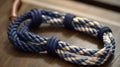 a close up of a blue and white rope on a wooden table with a wooden handle in the middle of the rope, with a knot on the end of Royalty Free Stock Photo