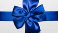 Close-up of blue wrapping ribbon in shape of bow for white gift box. Royalty Free Stock Photo