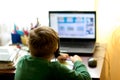 Selektive focus image.The boy learns with laptop at a distance remote learning,boy uses headphones with a microphone