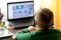 Selektive focus image.The boy learns with laptop at a distance remote learning,boy uses headphones with a microphone