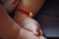 Close-up body parts baby infant chubby feet foot toes on golden ankle chain black isolated background innocent pure happy smile Royalty Free Stock Photo