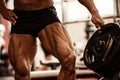 Close-up of bodybuilders muscular legs. Athlete man doing workout exercise in gym. Royalty Free Stock Photo